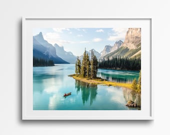 May include: A scenic landscape photograph featuring a turquoise lake surrounded by mountains and a small island with a group of trees. A red canoe is in the water, with a person paddling in the distance.