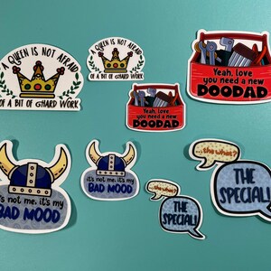 May include: A set of nine stickers featuring various designs and sayings. The stickers are printed on white, blue, and red backgrounds. Some of the stickers feature crowns, toolboxes, and speech bubbles. The text on the stickers includes "A Queen is not afraid of a bit of hard work", "Yeah, love you need a new DOODAD", "It's not me, it's my bad mood", and "The Special!"