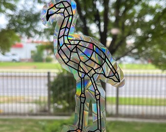 May include: A holographic sticker of a geometric flamingo with iridescent colors. The flamingo is standing on one leg with its neck curved.