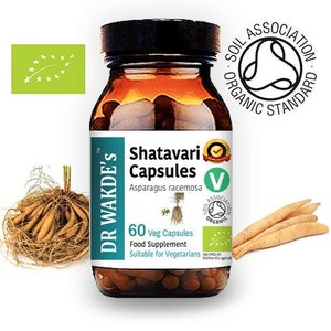 May include: A brown glass bottle with a white label that reads "Shatavari Capsules" and "Asparagus racemosa". The bottle contains 60 vegetarian capsules and is a food supplement. The bottle has a green and white label with the text "Soil Association Organic Standard".