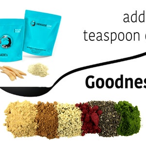 May include: A spoon with the text "Goodness" above it, filled with various powders and seeds. The powders are light brown, dark brown, white, red, and green. The seeds are black. Two bags of powder are in the background, one blue with the text "DR WAKDE'S" and the other blue with the text "DRWAKDE.COM".