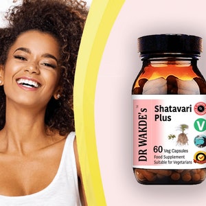 Op de afbeelding: Een bruine glazen fles met een zwarte dop die 60 vegetarische capsules bevat. Het etiket op de fles luidt "Dr Wakde's Shatavari Plus" en is een voedingssupplement dat geschikt is voor vegetari&euml;rs. De fles staat op een roze achtergrond.