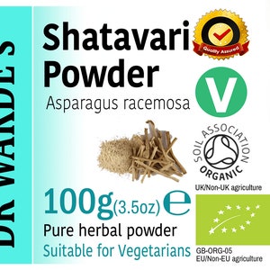 May include: A green and white label with the text "DR WAKDE'S" in black, "Shatavari Powder" in black, "Asparagus racemosa" in black, "100g (3.5oz) e" in black, "Pure herbal powder" in black, and "Suitable for Vegetarians" in black. The label also features a green "V" with "SOIL ASSOCIATION ORGANIC" in black and "UK/Non-UK agriculture" in black. There is a green label with a white star and a green stem with the text "GB-ORG-05 EU/Non-EU agriculture" in black. There is a yellow and red label with a checkmark and the text "Quality Assured" in black.
