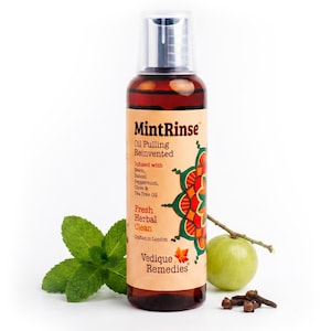 May include: A clear amber plastic bottle of MintRinse oil pulling mouthwash with a beige label featuring a colourful mandala design, text listing ingredients like neem and peppermint, and the brand name Vedique Remedies, with mint leaves and amla.
