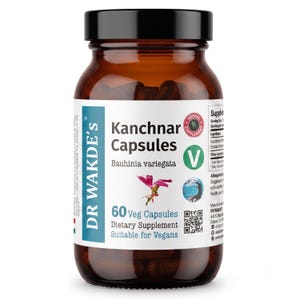 May include: A brown glass bottle with a black cap containing Kanchnar Capsules by Dr. Wakde's. The white label features the text Kanchnar Capsules, Bauhinia variegata, 60 Veg Capsules, and Dietary Supplement, along with a pink flower illustration.