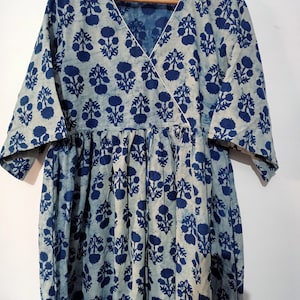 May include: A blue and white floral print wrap dress with a V-neckline and 3/4 sleeves.