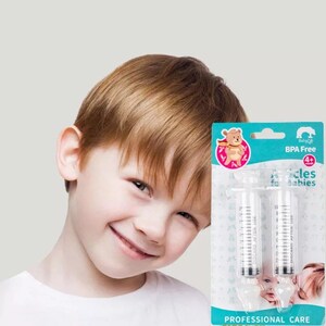 K&ouml;nnte beinhalten: Zwei transparente Plastikspritzen mit einem blauen und wei&szlig;en Etikett mit der Aufschrift "BPA Free 4+ Needles for Babies Professional Care". Das Etikett zeigt auch einen Comic-B&auml;ren, der einen roten Umhang tr&auml;gt.