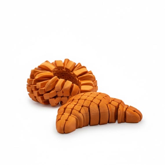 A UK-handmade articulated croissant that flexes and fidgets — food-shaped tactile toys scratch a very specific itch.