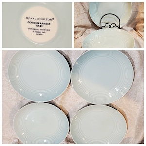 May include: Set of four light blue ceramic bowls with a ridged design. The bowls are dishwasher, microwave, and freezer safe. The bottom of one bowl shows the text "Royal Doulton® Gordon Ramsay Maze dishwasher, microwave & freezer safe ©WWRE"