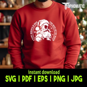 May include: Red sweatshirt with a white graphic of Santa Claus wearing sunglasses and a white beard. The graphic says "You should see the size of my sack".