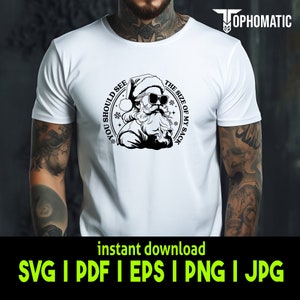 May include: A white t-shirt with a black and white graphic of Santa Claus wearing sunglasses and a Santa hat. The graphic is in a circle with the text "You should see the size of my sack" around it.