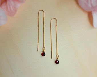 Subtle gold-plated threader earrings with garnet pendant