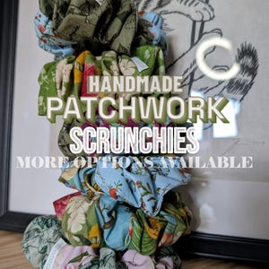 May include: A collection of handmade patchwork scrunchies in a variety of floral and patterned fabrics. The scrunchies feature shades of green, blue, pink, and red. The image includes the text "HANDMADE PATCHWORK SCRUNCHIES MORE OPTIONS AVAILABLE."