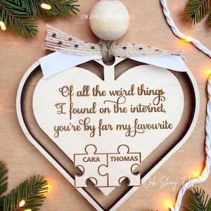 Puede incluir: Adorno de madera en forma de corazón con acabado marrón claro. El adorno presenta un diseño de corazón dentro de un corazón y el texto "Of all the weird things I found on the internet, you're by far my favourite." También tiene dos piezas de rompecabezas con los nombres "CARA" y "THOMAS".