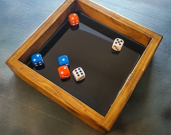 May include: A wooden tray with a black felt lining holds five dice. The dice are red, blue, and white with black dots.