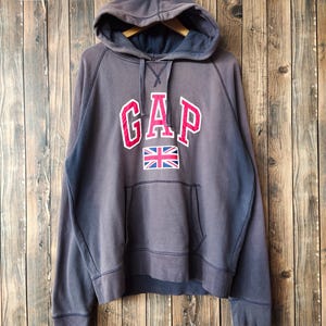 May include: A dark gray hooded sweatshirt with a red and white "GAP" logo and a small Union Jack flag.