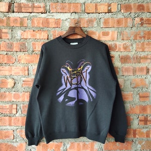 May include: Black sweatshirt with a purple and yellow graphic print of a monster with the word "WEBN" on it.