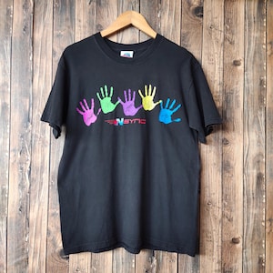 May include: Black t-shirt with a colorful handprint design. The handprints are in pink, green, purple, yellow, and blue. The text "NSYNC" is printed below the handprints in red and white.