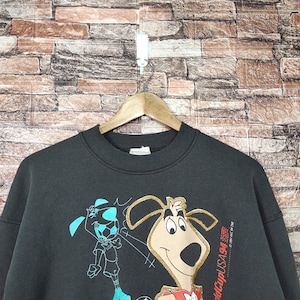 May include: Black sweatshirt with a cartoon dog and a soccer player graphic. The text "World Cup USA 94" is printed on the right side of the sweatshirt.