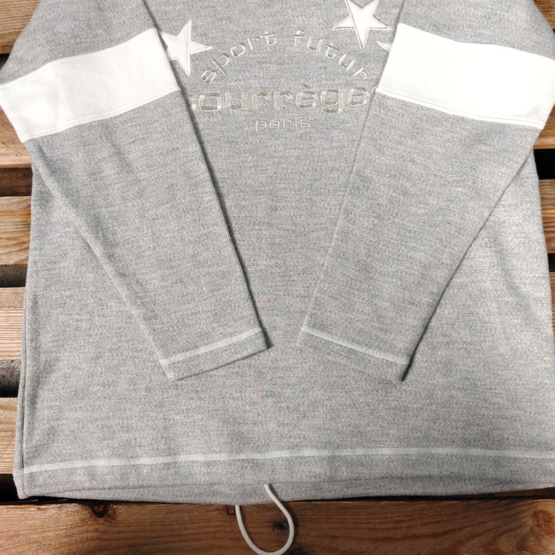 May include: Gray long-sleeve sweatshirt with white stripes on the sleeves and a white embroidered logo that says "sport futur" and "courr&egrave;ges paris".