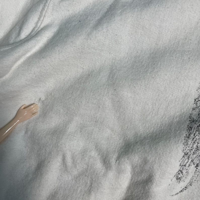 May include: Close-up of a white cotton fabric with a smooth texture. The fabric has a slight sheen and is wrinkle-free.