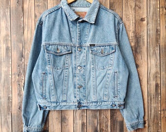 May include: Light blue denim jacket with a classic design. Features a collared neckline, button-down front, two chest pockets, and two side pockets. The jacket is made of durable denim material and has a vintage look. A versatile outerwear piece.