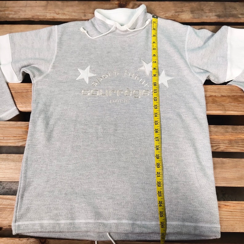 May include: Gray sweatshirt with a white collar and white trim. The sweatshirt has a white embroidered logo that says "sport futur" and "college" with a star on either side of the logo. The logo also says "paris" underneath.