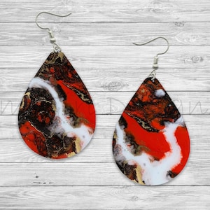 May include: A pair of teardrop-shaped earrings with a red, white, and black abstract marbled design. The earrings have silver hooks.