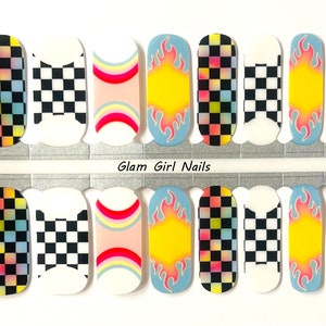 May include: A sheet of 10 nail wraps with a variety of designs, including checkered, rainbow, and flames. The nail wraps are on a white background with the text "Glam Girl Nails" printed on the sheet.