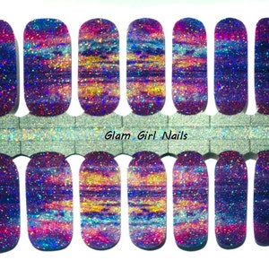 May include: A set of 10 nail wraps with a holographic glitter finish. The design features a purple, blue, and pink color scheme with a swirling, marbled effect. The nail wraps are labeled "Glam Girl Nails".