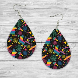 May include: A pair of black teardrop-shaped earrings with a colorful pattern of pinatas, fireworks, music notes, and hearts.