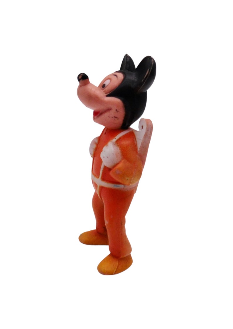 May include: A vintage plastic figurine of Mickey Mouse wearing an orange jumpsuit and a jetpack. The figurine is in good condition with some minor wear and tear.