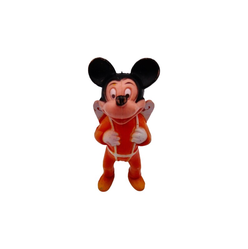 May include: A small plastic figurine of Mickey Mouse wearing an orange jumpsuit with white accents. He has black ears and a black nose.