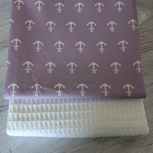 May include: Folded lavender fabric with a white anchor pattern on top of white waffle-weave fabric. The anchor pattern is evenly spaced. The fabrics are likely for home decor or textile projects. The measurements are in centimetres.