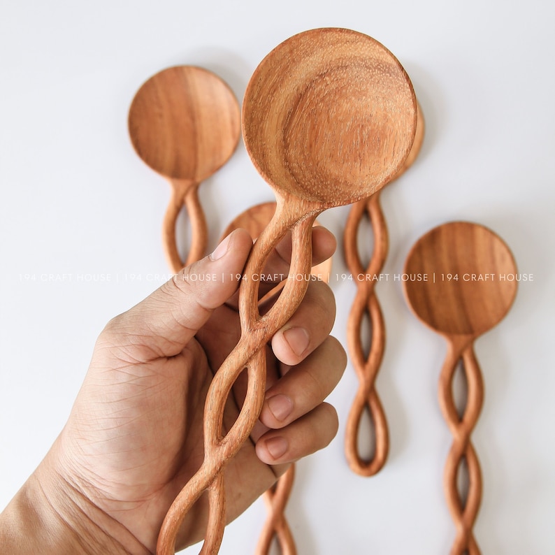 May include: Four wooden spoons with a unique twisted design. The spoons are made of natural wood and have a smooth, polished finish.