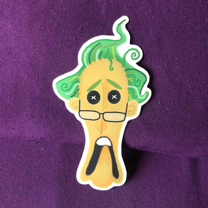 Puede incluir: Una pegatina de un personaje de dibujos animados con pelo verde, cara amarilla y ojos negros con forma de bot&oacute;n con una X en cada uno. El personaje lleva gafas y tiene la boca muy abierta.