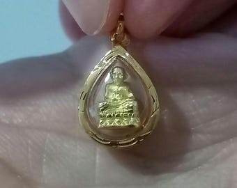 以下が含まれることがあります： 涙の形をした金のペンダントで、透明なガラスの囲いの中に小さな金の仏像が入っています。