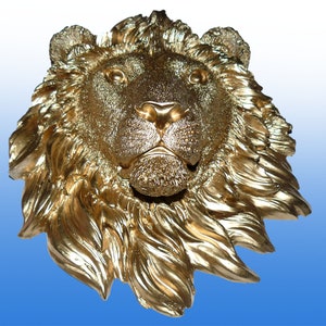 Könnte beinhalten: Eine goldene Löwenkopfskulptur mit einer detaillierten Mähne und einem realistischen Ausdruck. Die Skulptur ist aus einem glatten, glänzenden Material gefertigt und hat ein klassisches, elegantes Design.