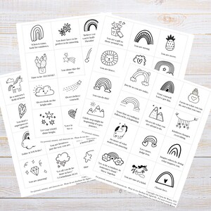 May include: A set of 24 printable cards featuring black and white illustrations of rainbows, stars, hearts, and other positive imagery. Each card includes an inspirational message such as "You are strong", "You are brave", and "You are amazing".