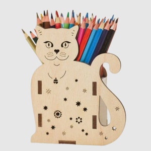 May include: A wooden cat-shaped pencil holder with a star and flower design. The holder is filled with colored pencils.