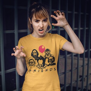 May include: A yellow t-shirt with a graphic of horror movie characters, including Pennywise, Freddy Krueger, Jason Voorhees, and Ghostface. The text "FRIENDS" is printed below the graphic.
