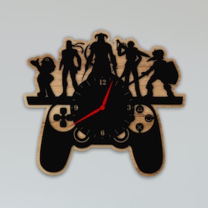 May include: A wooden wall clock shaped like a video game controller with a black silhouette of video game characters on top. The clock face is black with white numbers and a red hour hand.