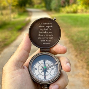 May include: A compass with a quote by Ralph Waldo Emerson on the lid: "Do not follow where the path may lead. Go instead where there is no path and leave a trail."