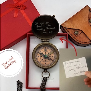May include: A brass compass with a chain, a red box, and a brown leather pouch. The compass has a glass cover with a handwritten message inside: "So you can find me in every lifetime xo- Ash".