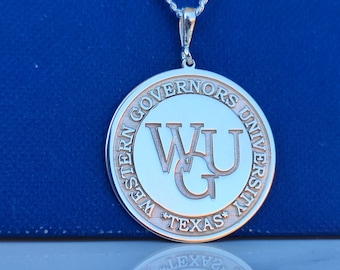 May include: Silver pendant necklace with a round charm featuring the Western Governors University logo. The charm is engraved with "Western Governors University" and "Texas" around the edge. The logo is a stylized "WGU" with a "G" in the center.