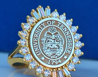 Könnte beinhalten: Goldring mit einem weißen und braunen Emblem der University of Tennessee, umgeben von klaren Strasssteinen.