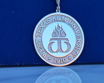 May include: A silver pendant necklace with a circular charm featuring the West Texas A&M University logo. The logo is a stylized "W" with flames above it and the words "West Texas A&M University" and "1910" around the edge.