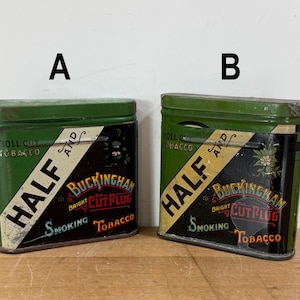 May include: Two vintage green metal tobacco tins. Each tin has a black and white diagonal banner with the words "HALF" and "BUCKINGHAM BRIGHT CUT PLUG SMOKING TOBACCO". The tins are rectangular with rounded tops.
