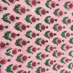 Pu&ograve; includere: Tessuto rosa con un motivo ripetitivo di foglie verdi e fiori rossi e bianchi.