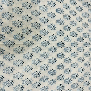 Pu&ograve; includere: Tessuto bianco con un motivo ripetitivo di piccoli ramoscelli fioriti blu. I ramoscelli sono stilizzati e hanno un design semplice ed elegante.